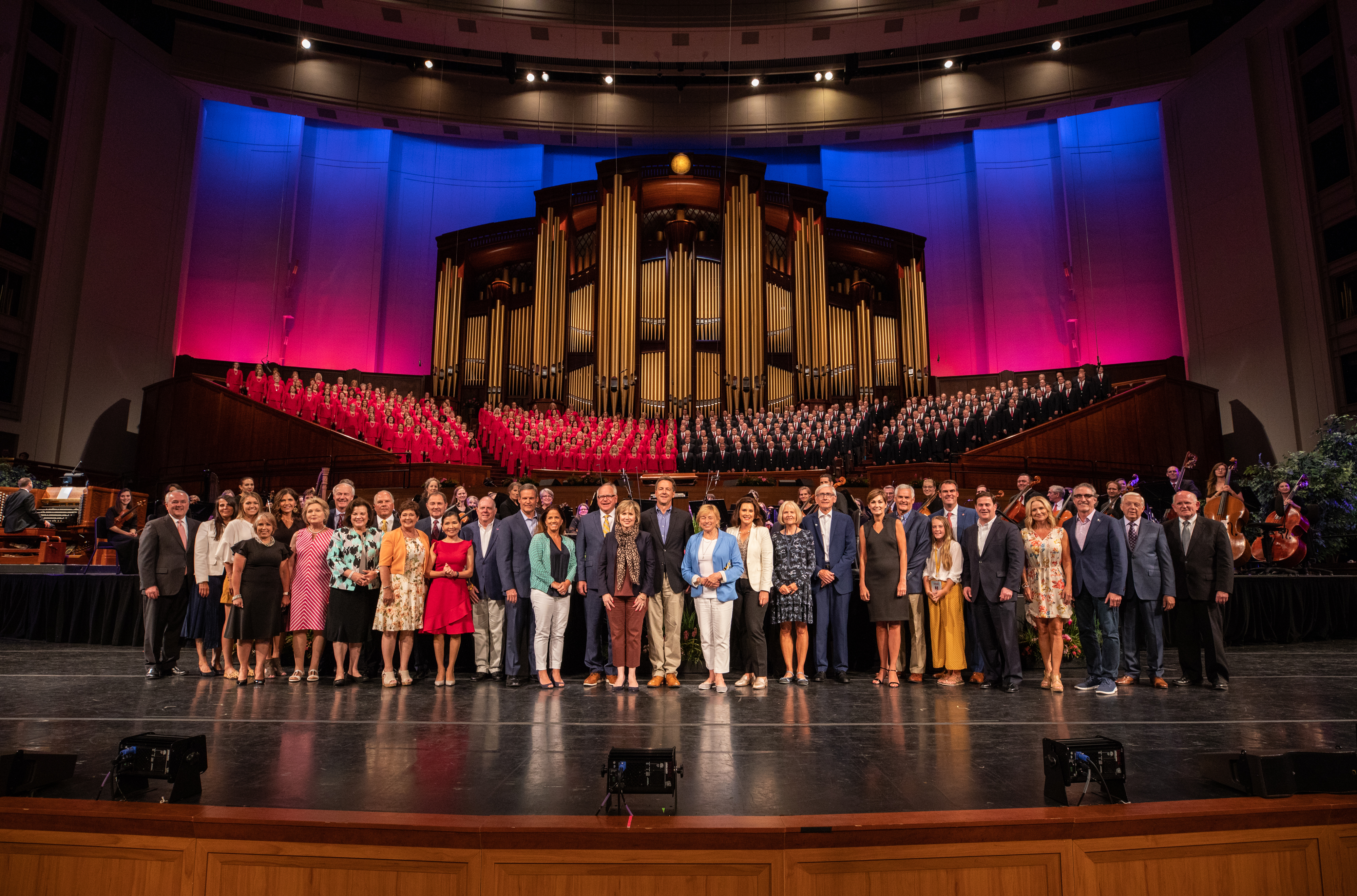 Governors gather on the LDS Conference Center stage with the Tabernacle Choir after a private concert.
