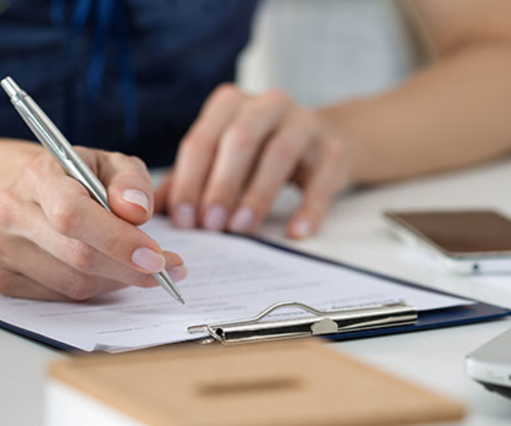 Close-up of female hands. Woman writing something  sitting at her office