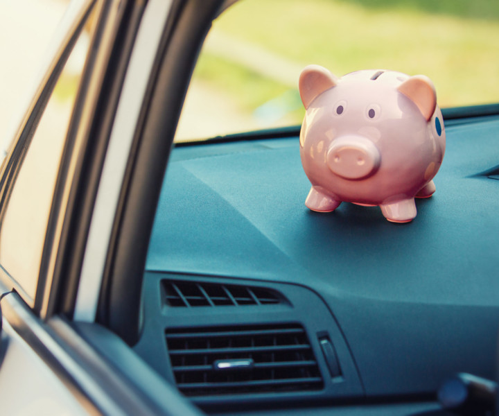 Pink piggy money box inside a car transportation. Saving money for vehicle purchase. Successful financial planning and banking concept. Economic investment for future. Buy or loan automobile.