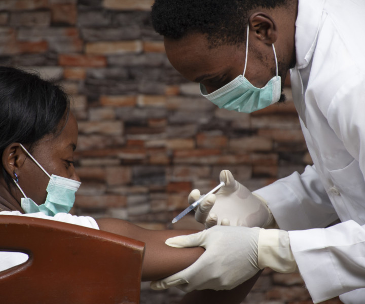 african doctor injecting an african woman with a vaccine for covid 19