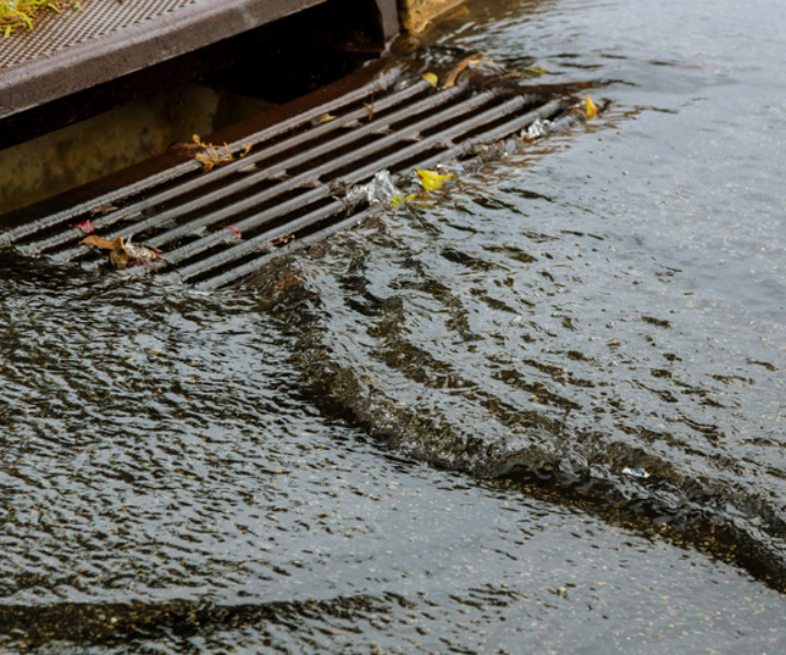 Water gushing from storm sewer following very heavy rainfall of the road after heavy rain.