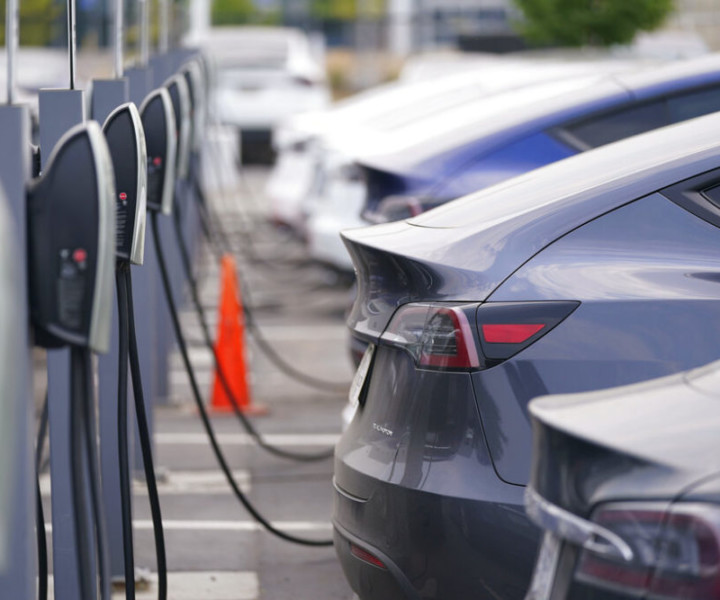 This Aug. 23, 2020 photo shows a long line of unsold 2020 models charge outside a Tesla dealership in Littleton, Colo.  The European Union is lacking sufficient charging infrastructure for electric vehicles, according to the bloc's external auditor. In a report published Tuesday, April 13, 2021, the European Court of Auditors said users are gaining more harmonized access to charging networks but the EU is still “a long way from reaching its Green Deal target of 1 million charging points by 2025." (AP Photo/David Zalubowski)