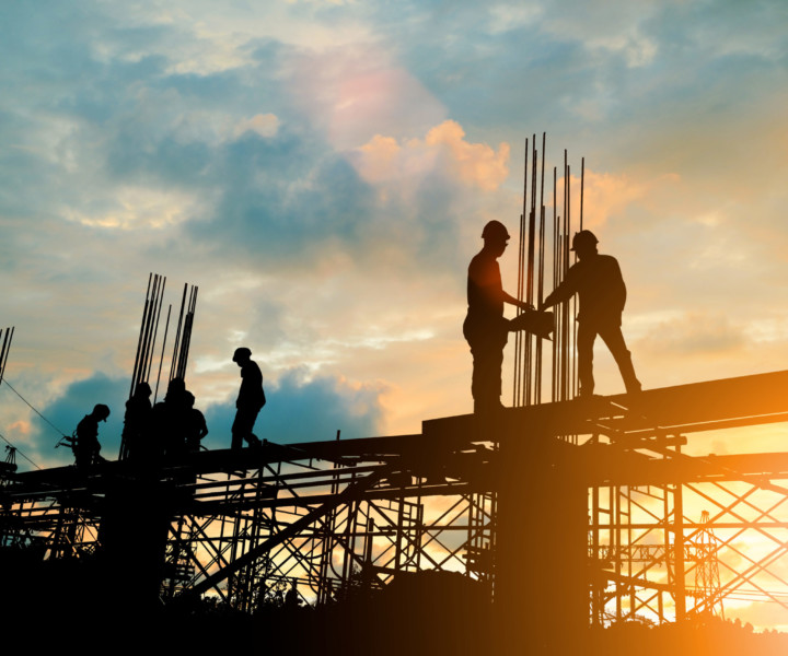 Silhouette of engineer and construction team working at site over blurred background sunset pastel for industry background with Light fair.