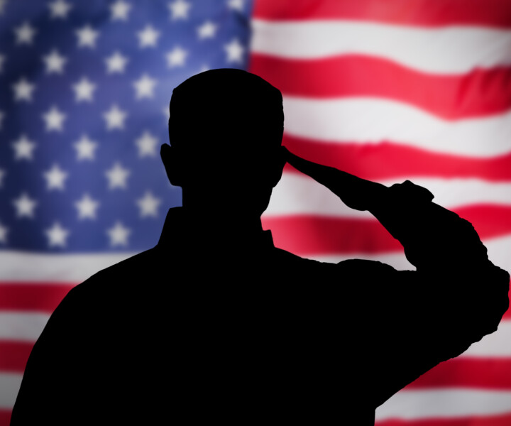 US Military Soldier Saluting Flag. National Hero And Veteran