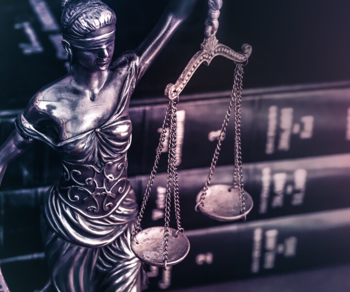 Legal law concept image Scales of Justice and case books on desk.