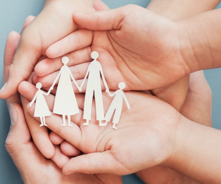 Adult and children hands holding paper family cutout, family home, foster care, homeless charity support concept, family mental health, international day of families